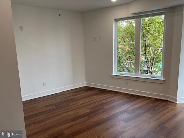 unfurnished room featuring plenty of natural light and dark hardwood / wood-style floors