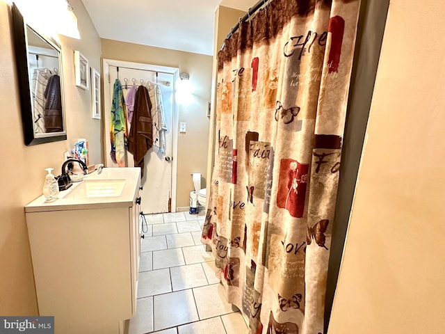 bathroom with toilet, vanity, and tile patterned floors