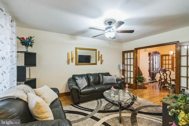 living room featuring ceiling fan, french doors, and light hardwood / wood-style floors