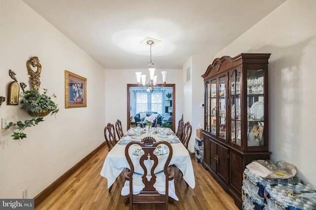 dining area with a chandelier and light wood-type flooring