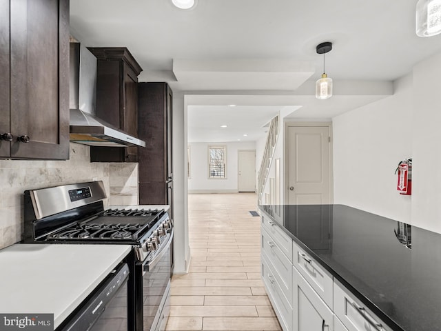 kitchen with dark brown cabinetry, stainless steel gas range, white cabinetry, light hardwood / wood-style flooring, and wall chimney range hood