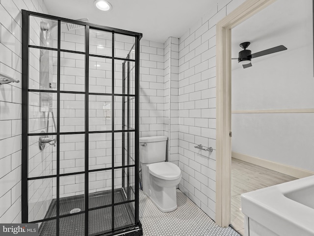 bathroom with toilet, tiled shower, ceiling fan, and tile patterned floors