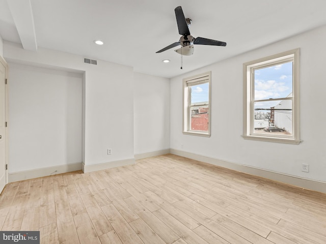 unfurnished room featuring a wealth of natural light, ceiling fan, and light hardwood / wood-style flooring