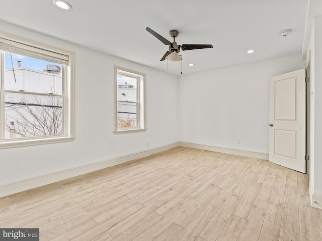 empty room featuring ceiling fan, light hardwood / wood-style floors, and a healthy amount of sunlight