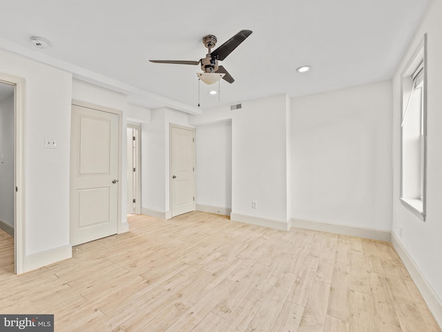 spare room with light wood-type flooring and ceiling fan