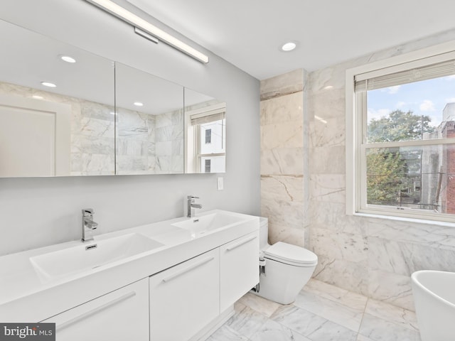 bathroom featuring a wealth of natural light, vanity, and toilet