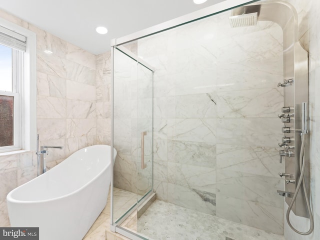 bathroom featuring tile walls and separate shower and tub