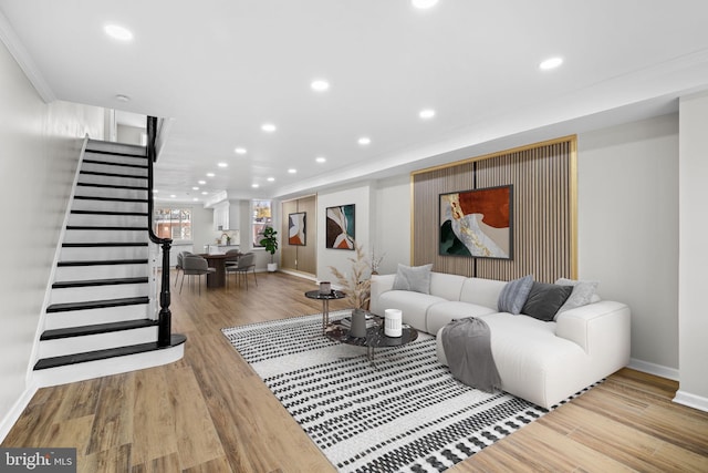 living room with light hardwood / wood-style floors and crown molding