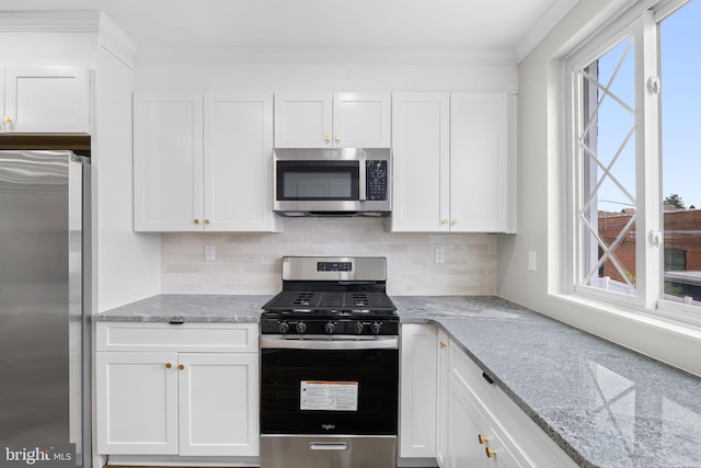 kitchen featuring white cabinets, appliances with stainless steel finishes, backsplash, and light stone countertops