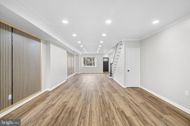 unfurnished living room with light hardwood / wood-style flooring and crown molding