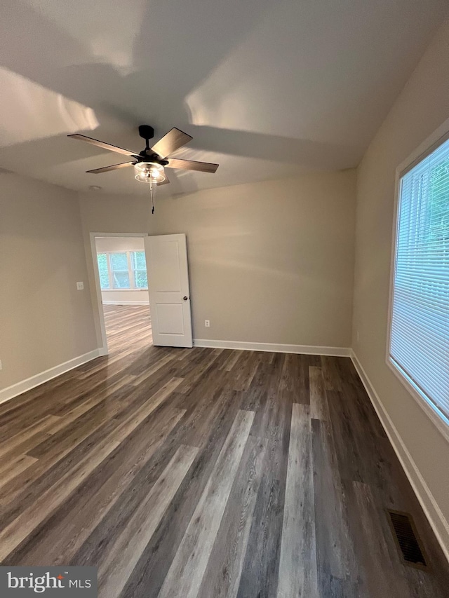 spare room featuring ceiling fan and dark wood-type flooring