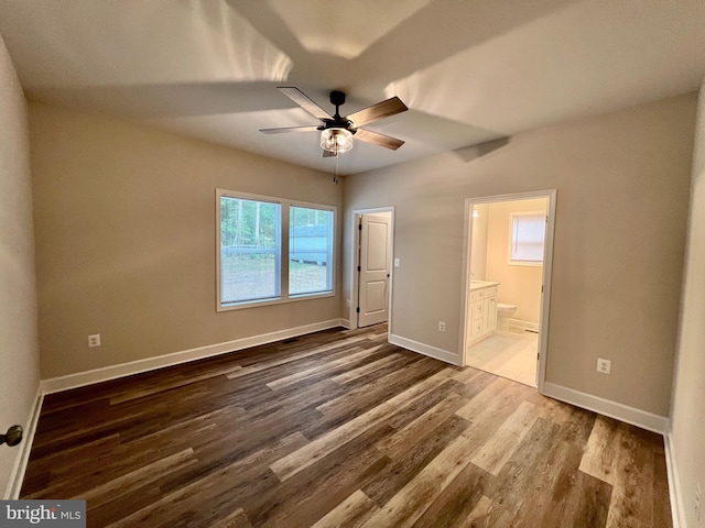 unfurnished bedroom featuring ceiling fan, ensuite bathroom, and wood-type flooring