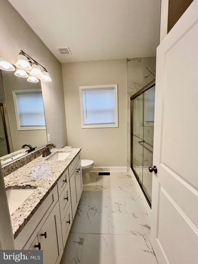 bathroom with a shower with door, vanity, and toilet