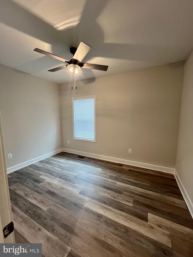 spare room featuring ceiling fan and dark wood-type flooring