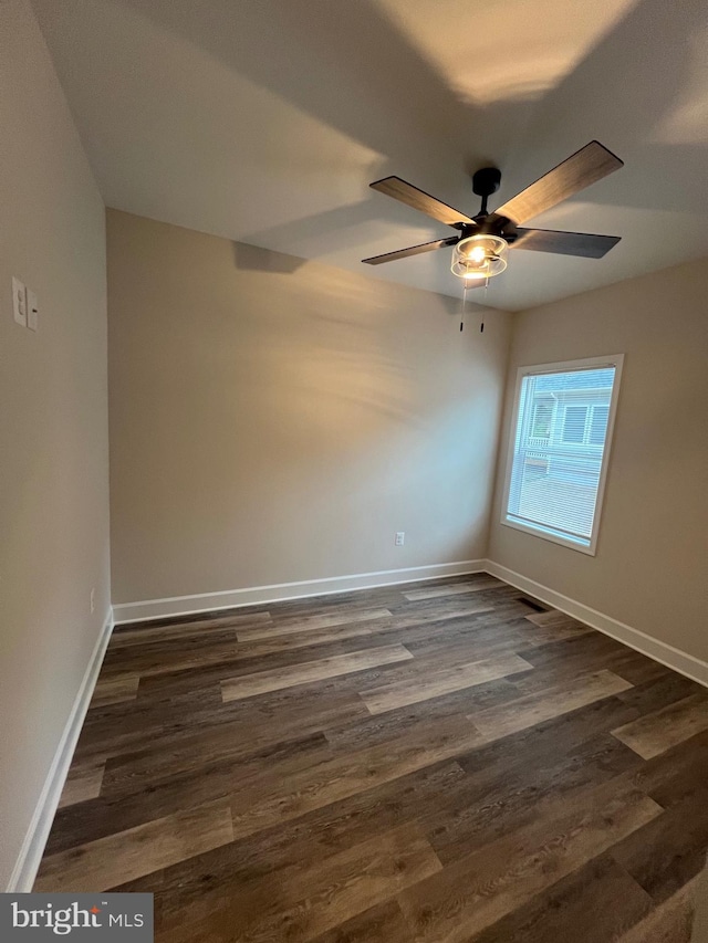 empty room with ceiling fan and dark hardwood / wood-style flooring