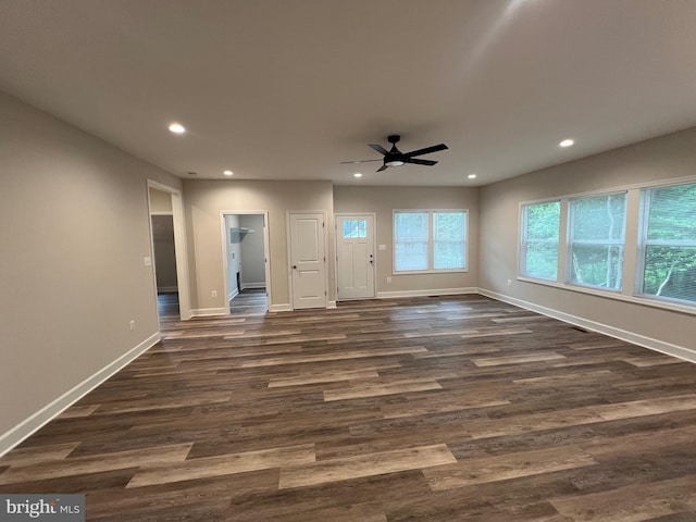 unfurnished living room with dark hardwood / wood-style flooring and ceiling fan