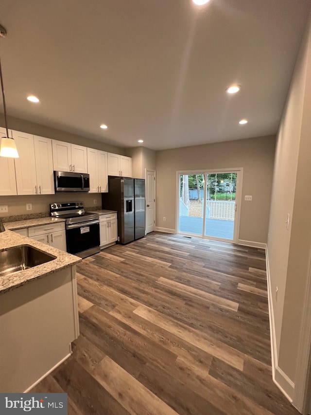 kitchen featuring pendant lighting, white cabinets, sink, dark hardwood / wood-style flooring, and stainless steel appliances