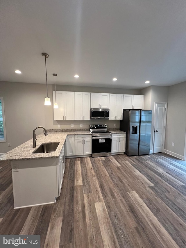 kitchen featuring dark wood-type flooring, white cabinets, sink, hanging light fixtures, and stainless steel appliances