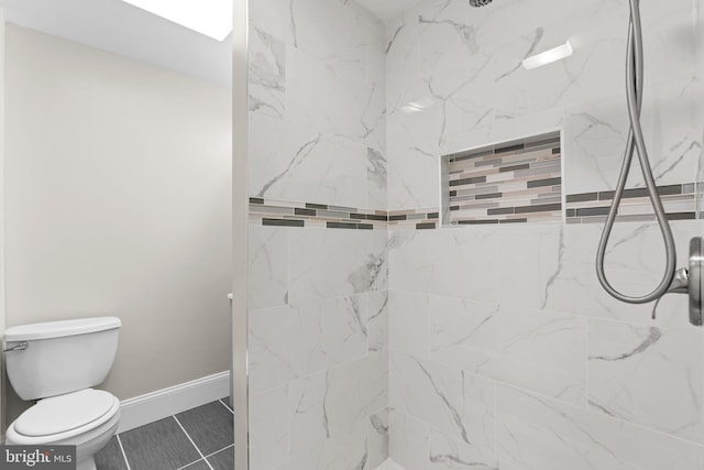 bathroom featuring toilet and tiled shower