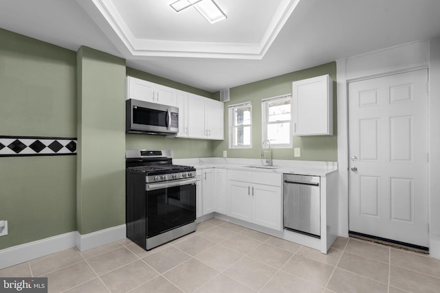 kitchen with white cabinetry, appliances with stainless steel finishes, light tile patterned floors, a raised ceiling, and sink