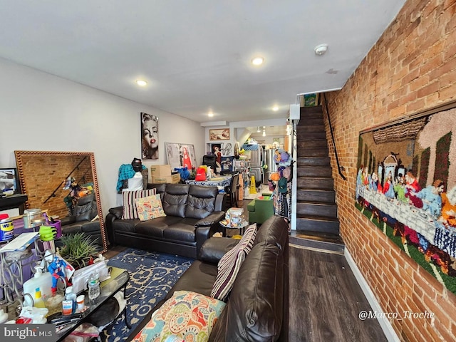 living room with hardwood / wood-style flooring and brick wall