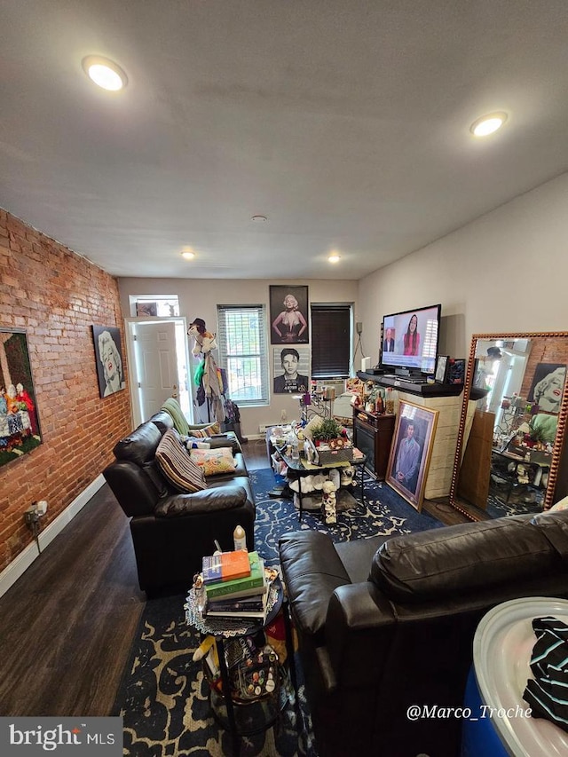 living room featuring wood-type flooring and brick wall