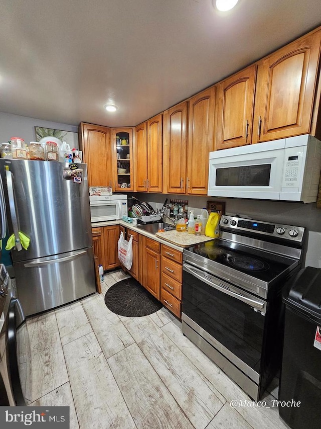 kitchen featuring appliances with stainless steel finishes and light hardwood / wood-style flooring