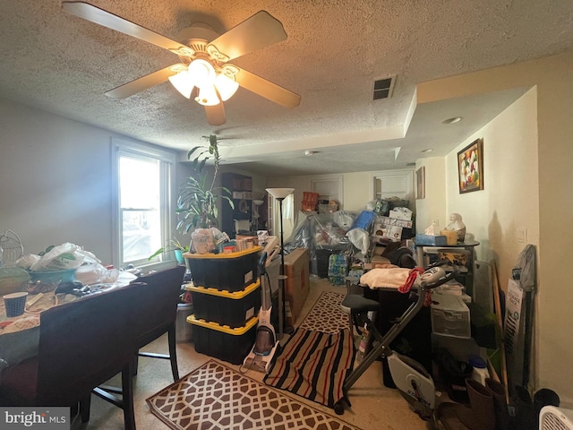 interior space featuring ceiling fan, light colored carpet, and a textured ceiling