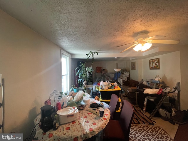 dining area with a textured ceiling and ceiling fan