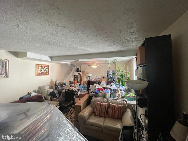 living room featuring ceiling fan and a textured ceiling