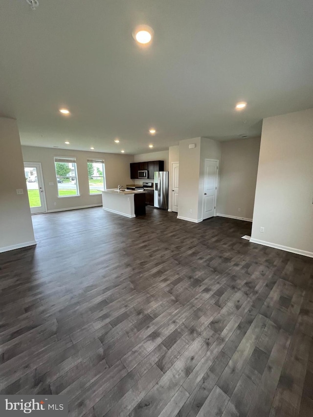 unfurnished living room with dark wood-type flooring