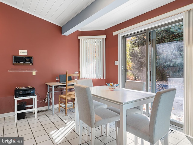 tiled dining space featuring beamed ceiling