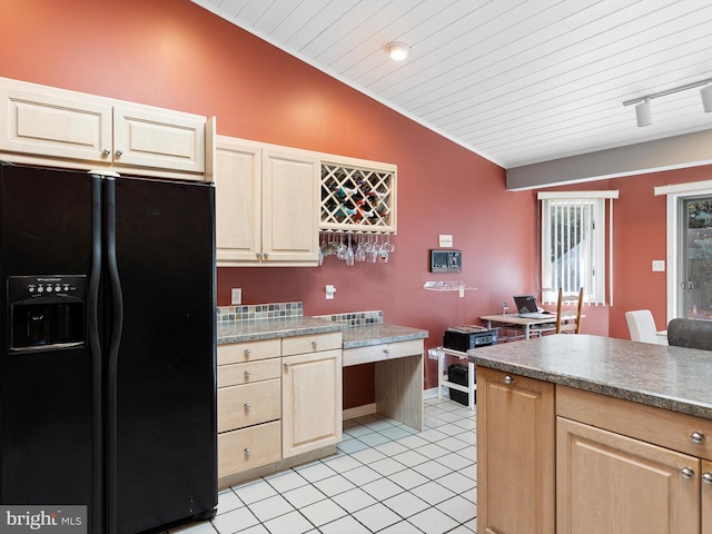 kitchen with light tile patterned floors, wood ceiling, black fridge, and vaulted ceiling