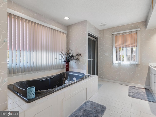 bathroom featuring vanity, tile patterned flooring, a textured ceiling, and a bathtub