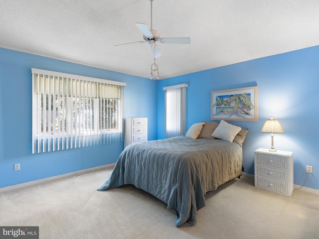 carpeted bedroom with a textured ceiling and ceiling fan