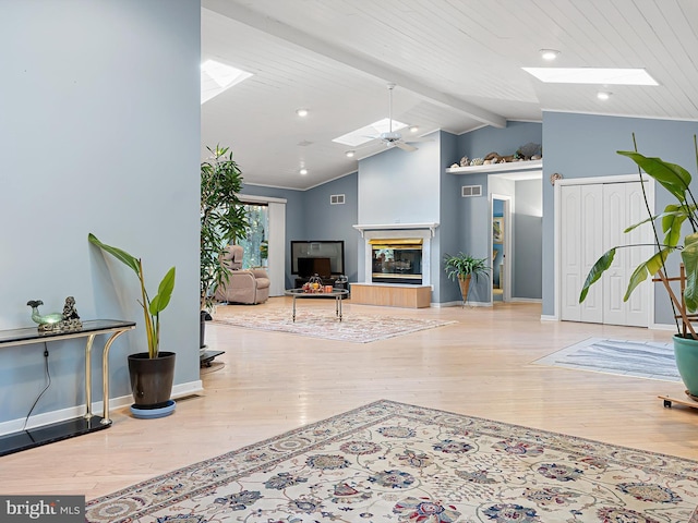 living room featuring vaulted ceiling with skylight, wood ceiling, and light hardwood / wood-style floors