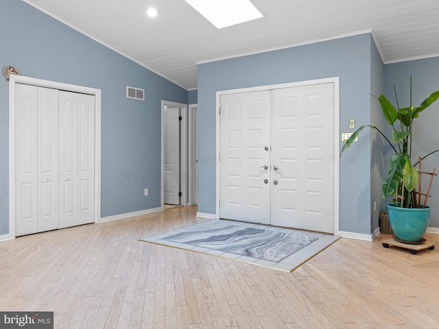 entrance foyer with light hardwood / wood-style floors, lofted ceiling, and crown molding