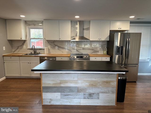 kitchen featuring white cabinetry, wall chimney exhaust hood, and stainless steel appliances