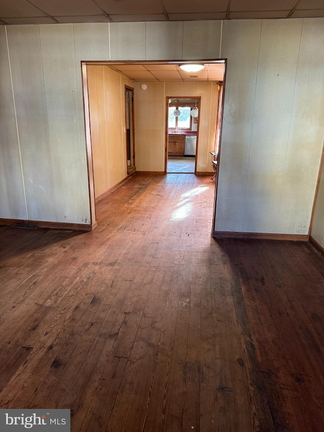 empty room featuring dark hardwood / wood-style flooring and a paneled ceiling