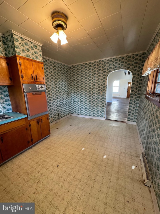 interior space with ceiling fan and crown molding