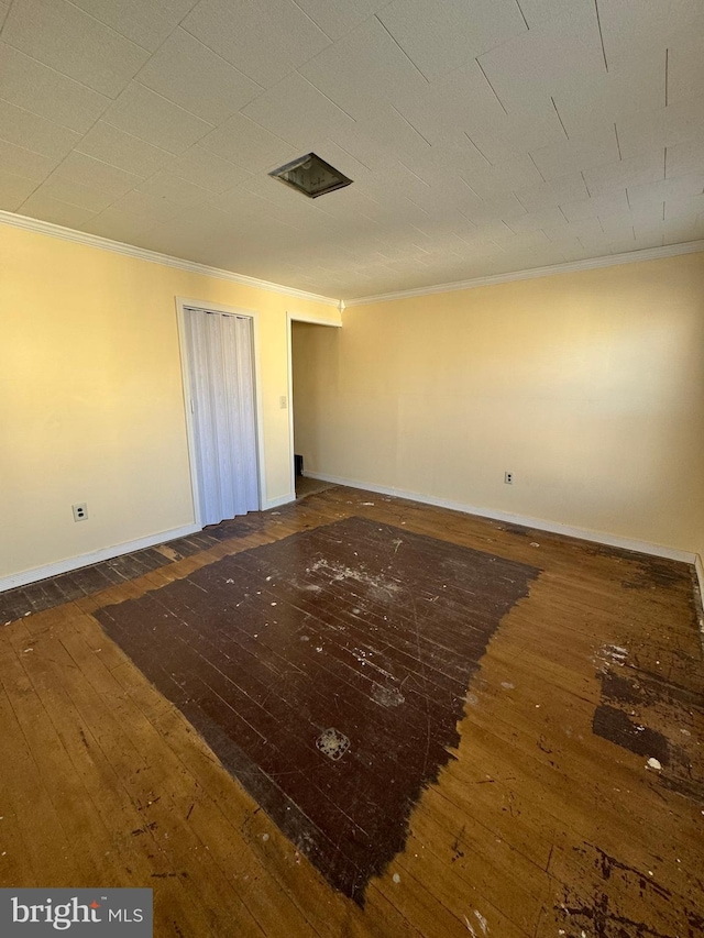 spare room featuring ornamental molding and dark hardwood / wood-style flooring