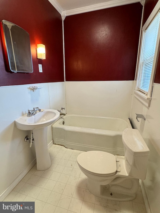 bathroom with a tub to relax in, toilet, and crown molding