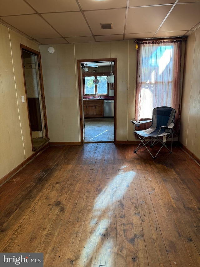 unfurnished room featuring a wealth of natural light, dark hardwood / wood-style floors, sink, and a drop ceiling