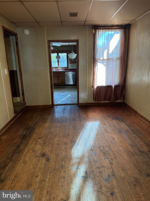 spare room featuring a drop ceiling and dark hardwood / wood-style floors