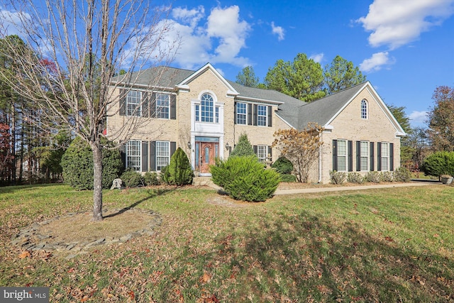 colonial inspired home featuring a front lawn