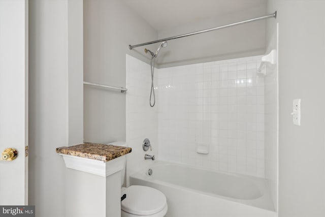 bathroom featuring toilet and tiled shower / bath