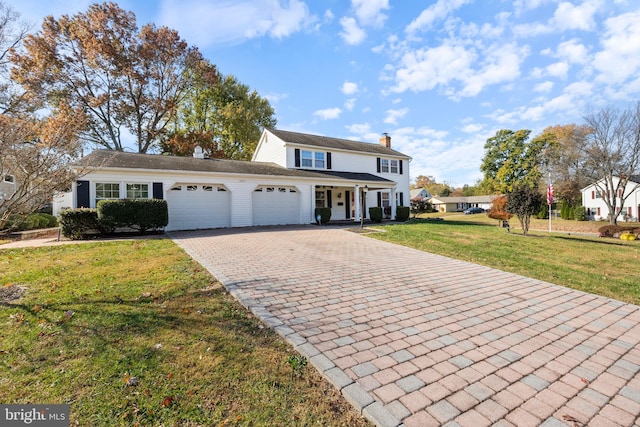 view of front property featuring a front lawn and a garage