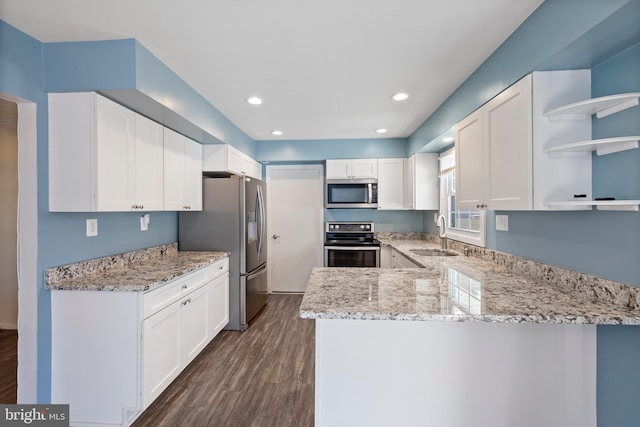 kitchen with dark wood-type flooring, white cabinetry, light stone counters, and stainless steel appliances