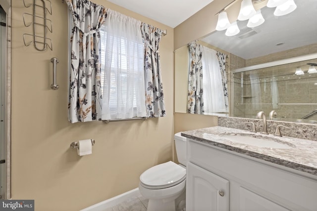 bathroom with vanity, tile patterned floors, toilet, and an enclosed shower