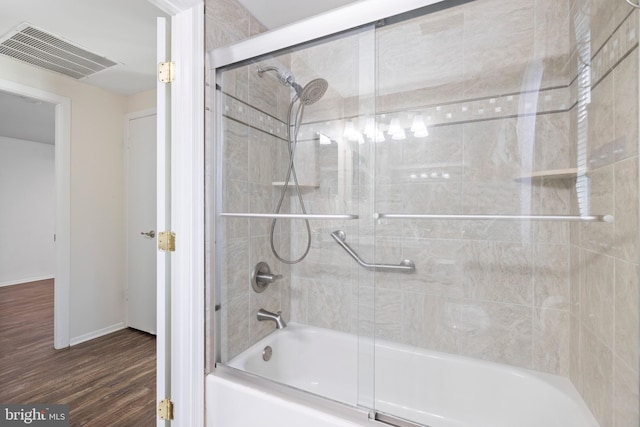 bathroom featuring enclosed tub / shower combo and wood-type flooring